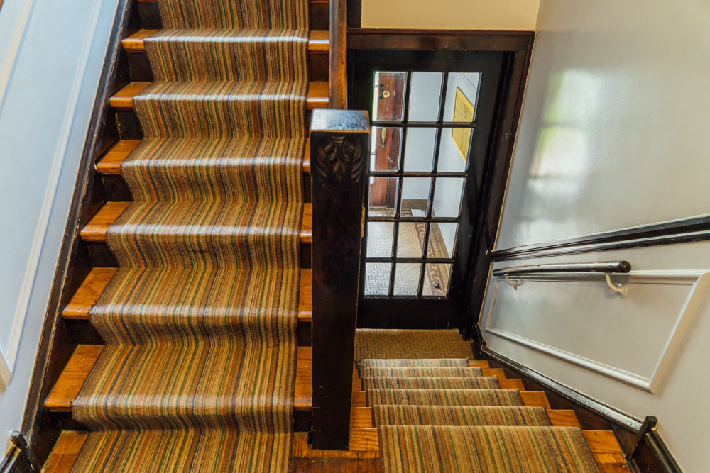 a set of stairs with wooden treads and a glass door