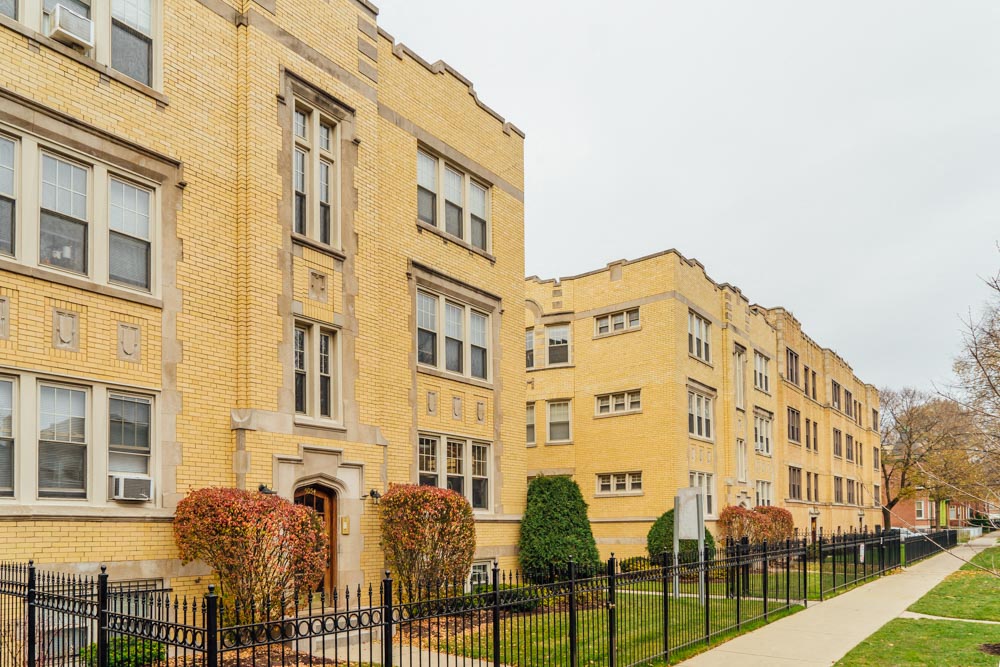 a row of brick apartment buildings on a sidewalk