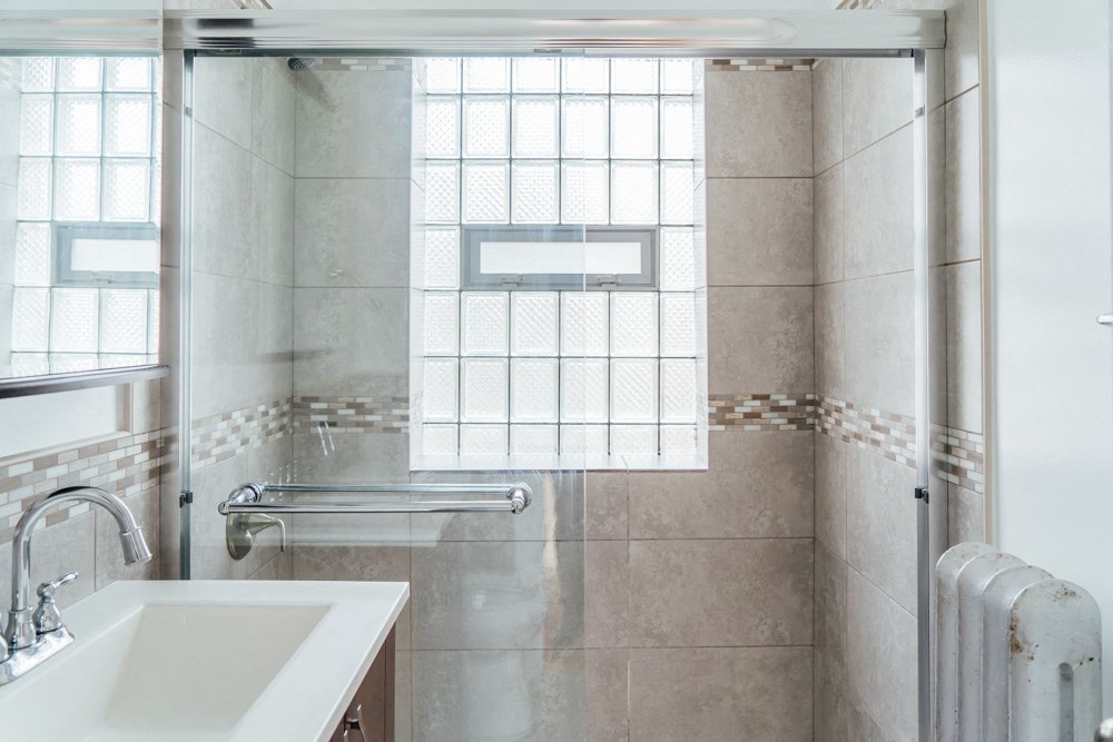 a bathroom with a sink and a shower and a window