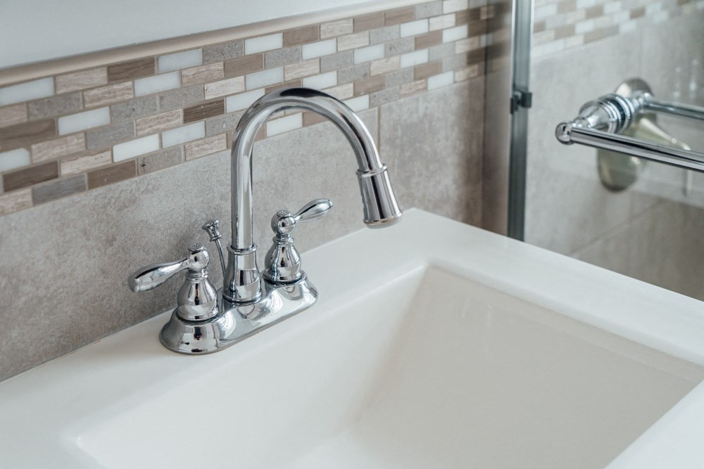 a white sink with a chrome faucet in a bathroom
