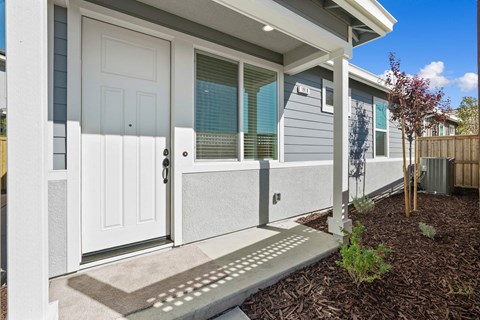 A house with a white door and a grey wall.
