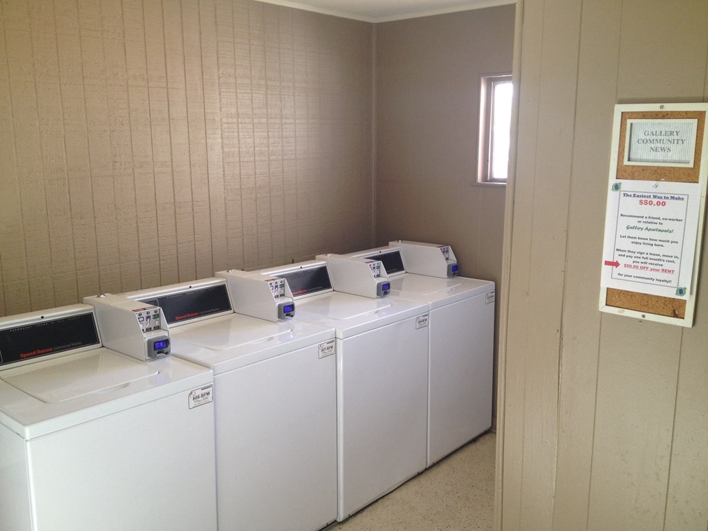 four washers and dryers in a row in a laundry room