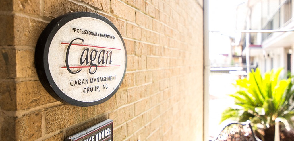 a sign on the side of a brick wall