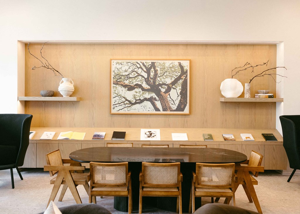 a dining room with a table and chairs and a painting on the wall