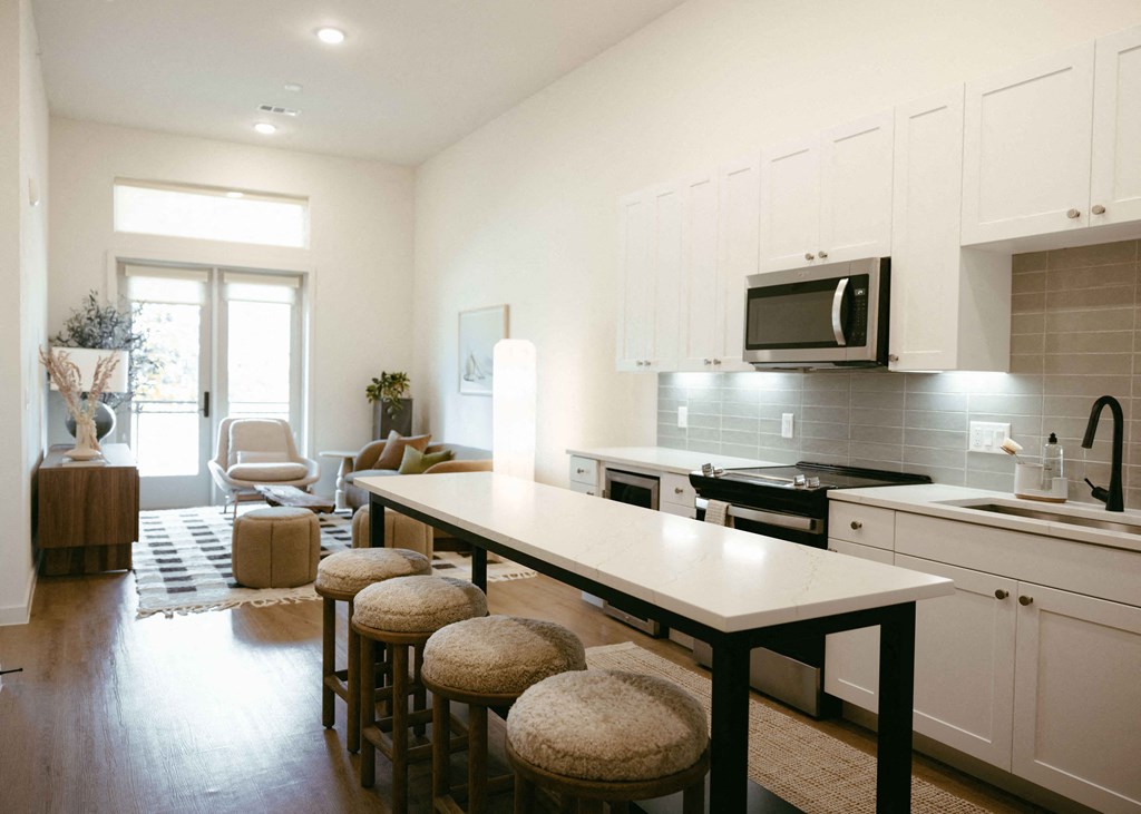 a kitchen and living room with an island and stools