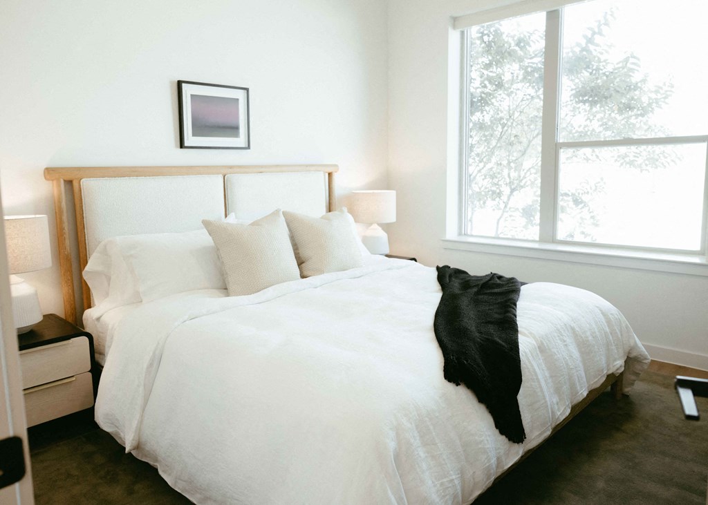 a bedroom with a bed and a large window