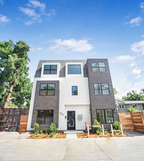 A modern two-story house with a white front door and windows.