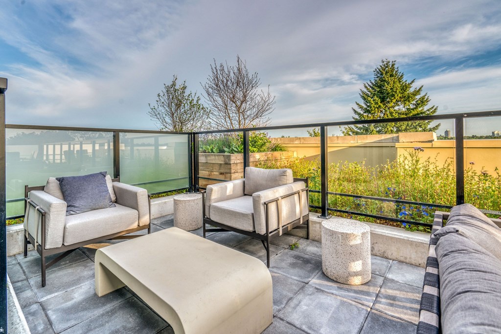 a living room with a couch and chairs and a balcony