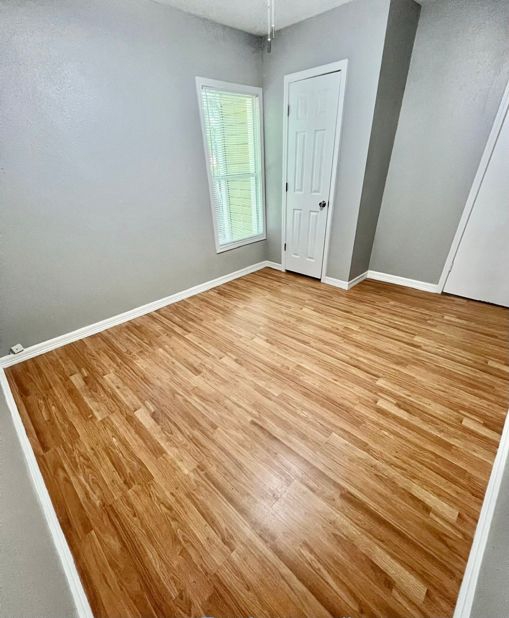 an empty room with wood flooring in a home