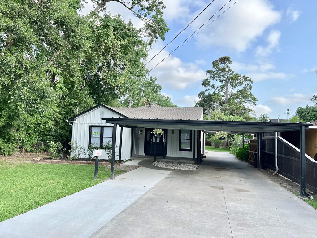 a small white house with a covered porch and a walkway