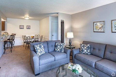 a living room with couches and a glass coffee table