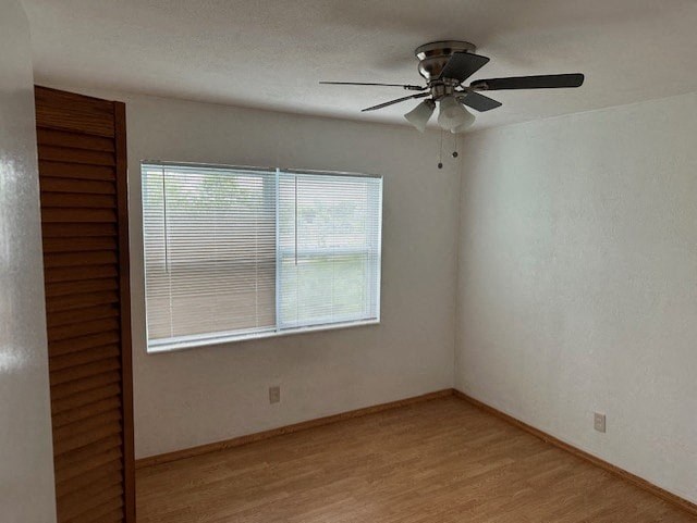 an empty room with a ceiling fan and a window