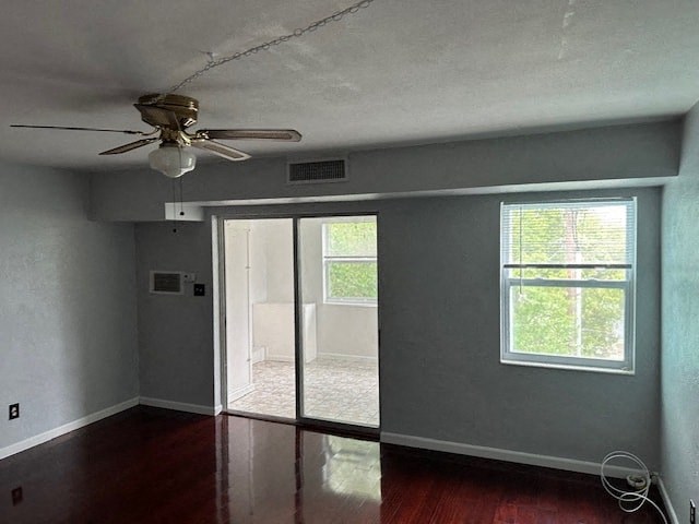 an empty living room with a ceiling fan and a sliding glass door