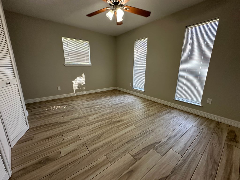 a living room with wood floors and a ceiling fan