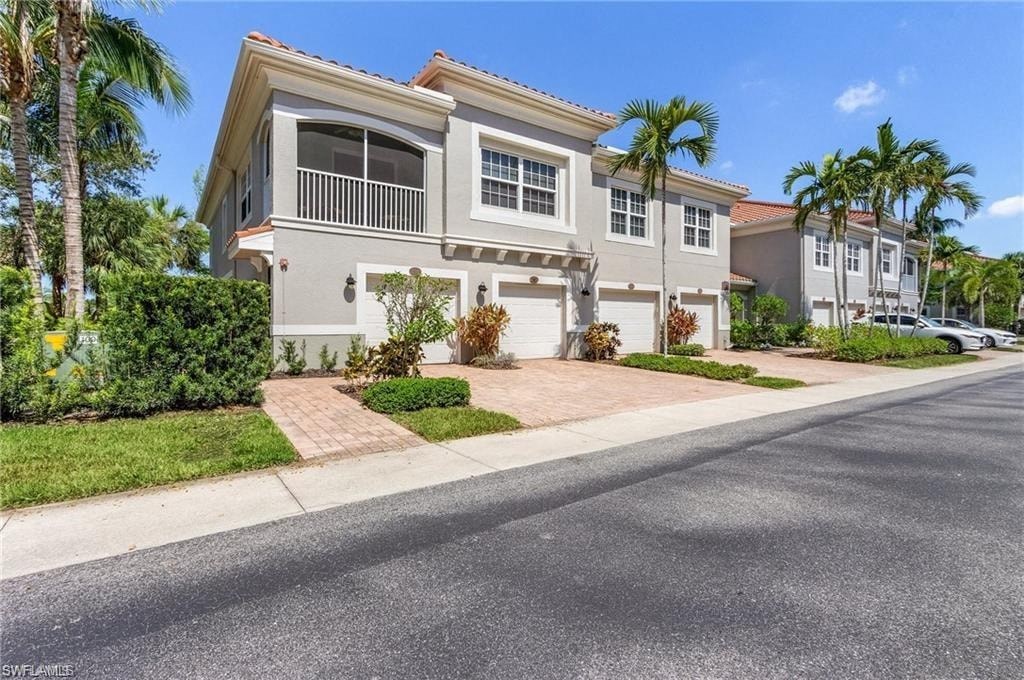 a house with a sidewalk and palm trees in front of it