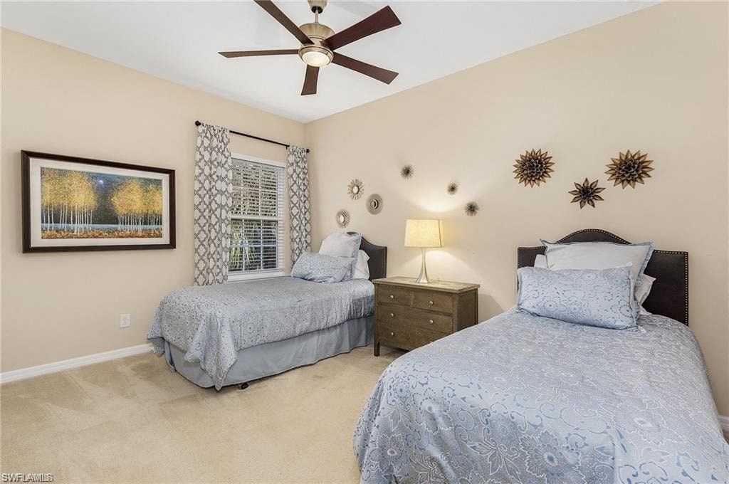 a bedroom with two beds and a ceiling fan