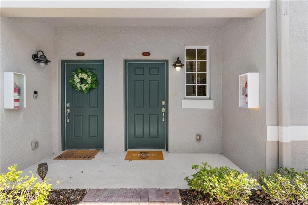 the front door of a house with two green doors