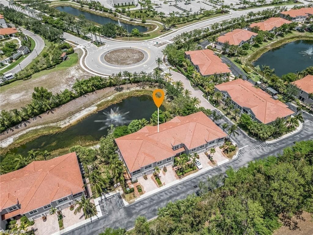 an aerial view of a park with a fountain and a parking lot
