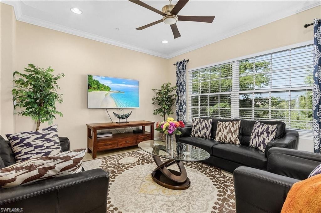 a living room with black leather furniture and a ceiling fan