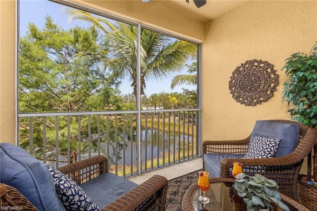 a balcony with chairs and a table and a window
