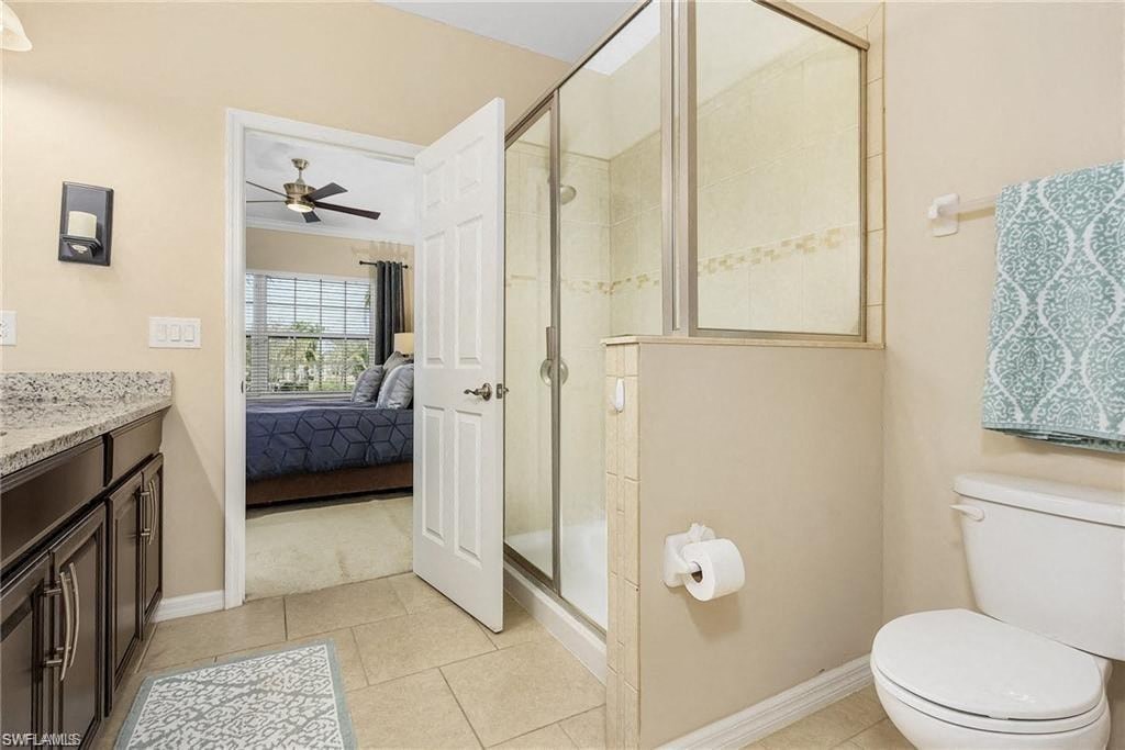 a bathroom with a shower and a toilet and a bedroom
