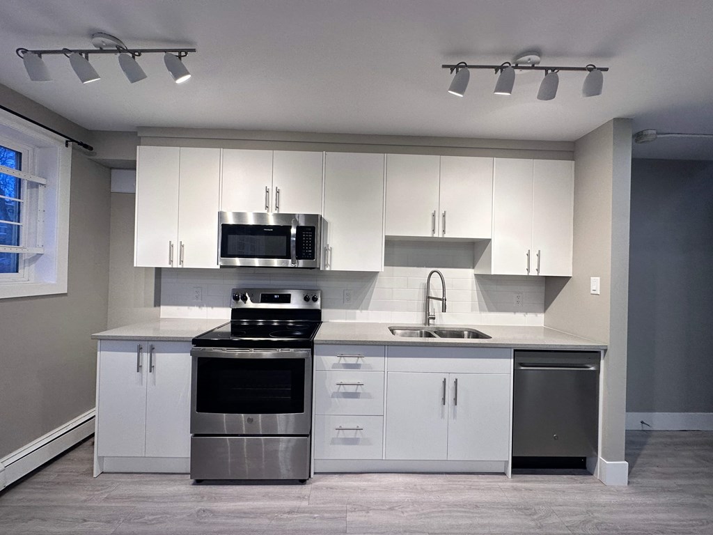 a kitchen with white cabinets and stainless steel appliances