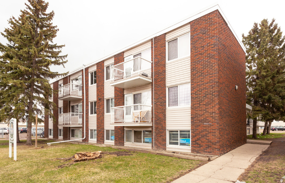 the exterior of an apartment building with a sidewalk