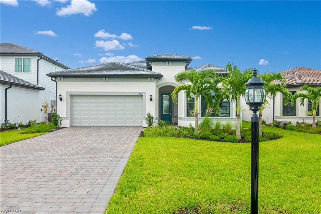 a house with a driveway and palm trees in front of it