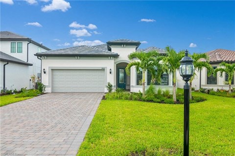 a house with a driveway and palm trees in front of it