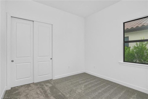 an empty room with white walls and a window