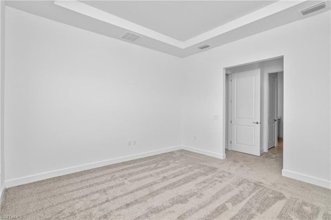an empty living room with white walls and a door to a closet