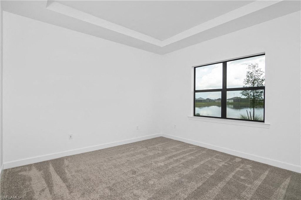 an empty living room with a large window and carpet