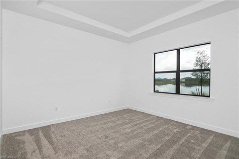 an empty living room with a large window and carpet