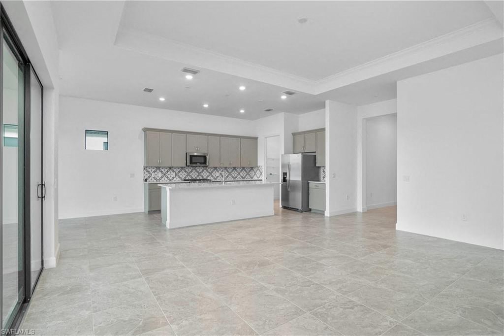 the living room and kitchen of a new home with no furniture