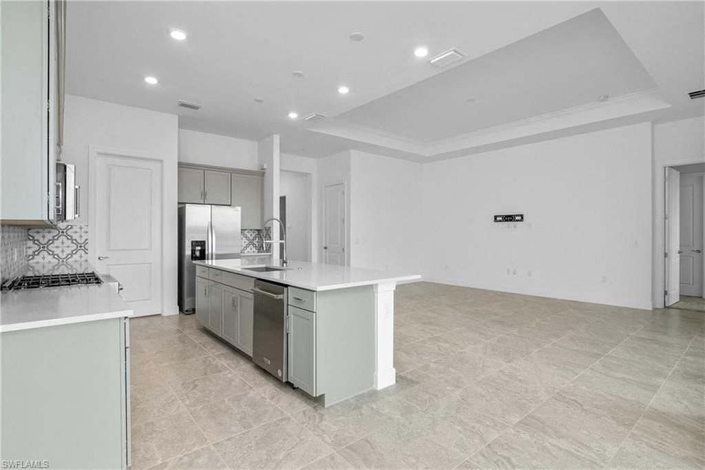 a large white kitchen with an island in the middle