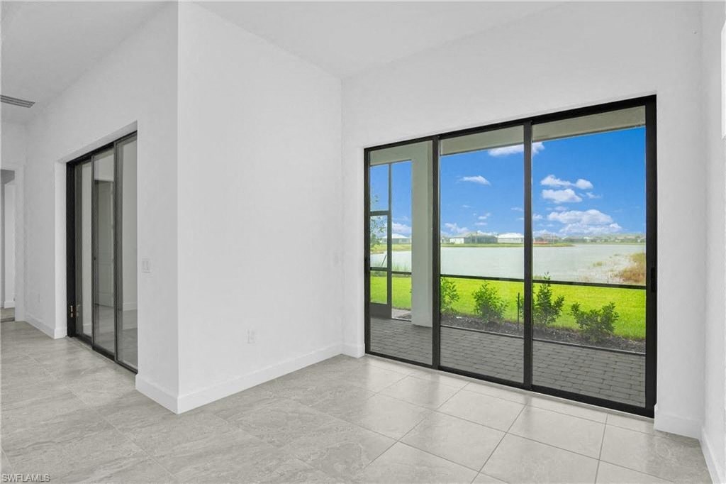 the living room has large windows and a tiled floor
