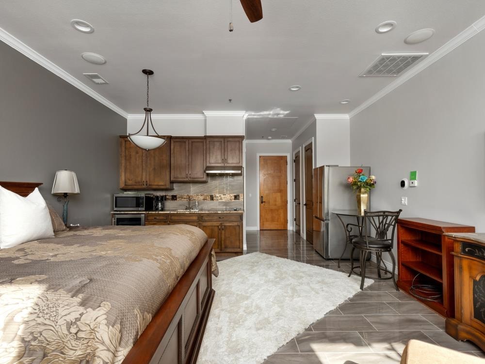 a bedroom with a bed and a kitchen in the background