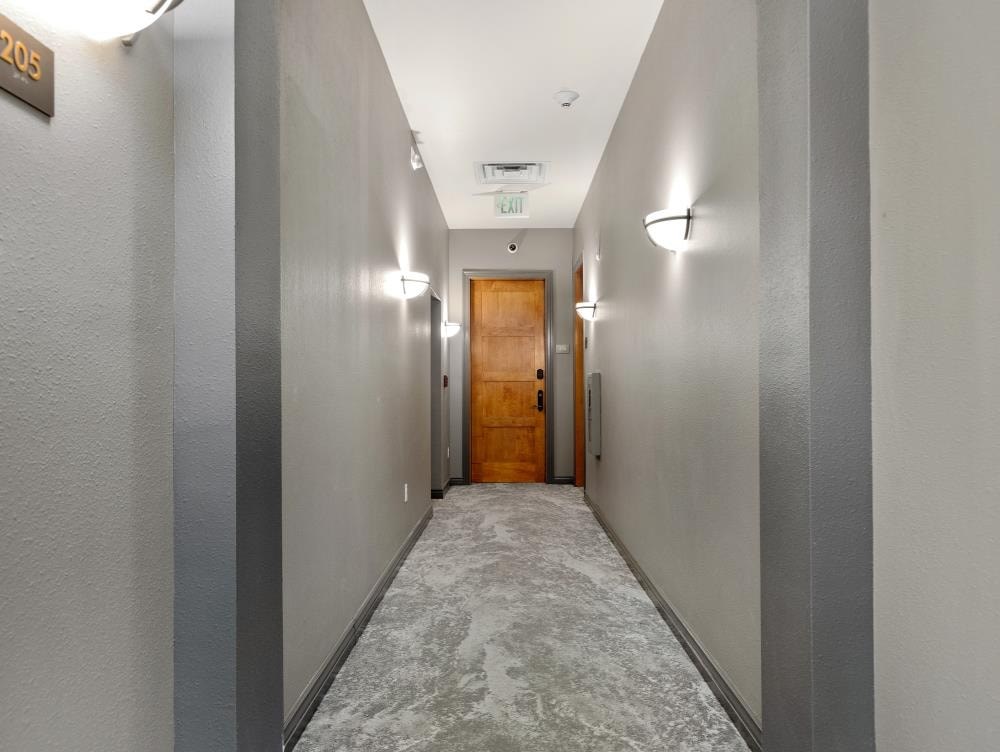 a long hallway with a wooden door in the middle