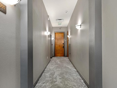 a long hallway with a wooden door in the middle