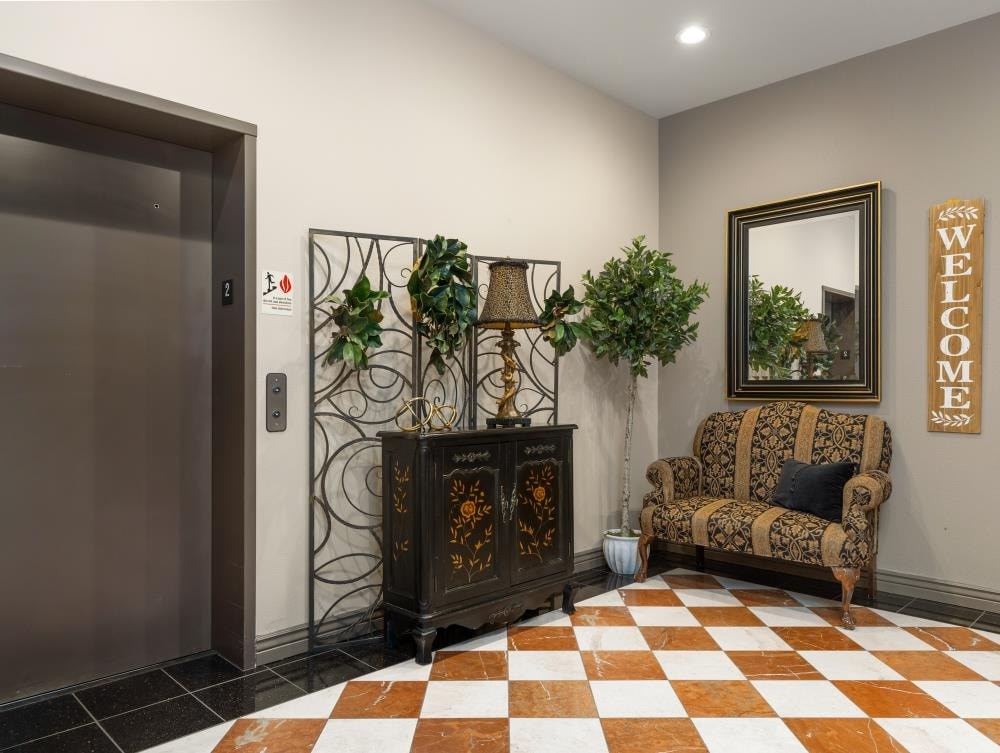 a lobby with a chair and a dresser with plants