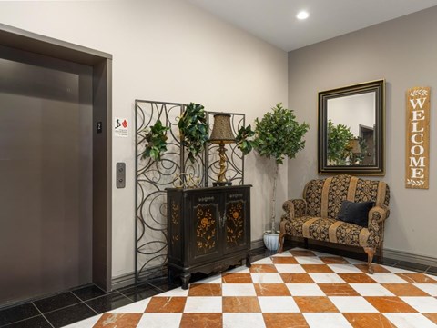 a lobby with a chair and a dresser with plants