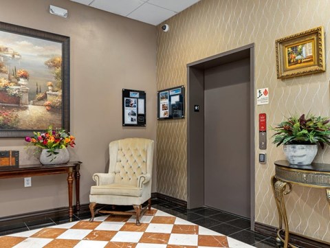 a lobby with a chair and a door    and a painting