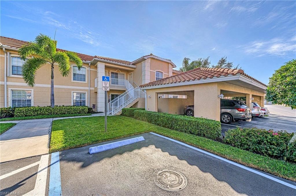 a parking lot in front of an apartment building with palm trees
