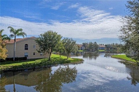 a house next to a body of water with trees