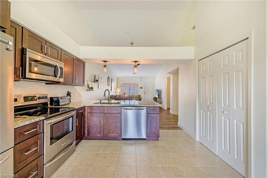 a large kitchen with stainless steel appliances and wooden cabinets
