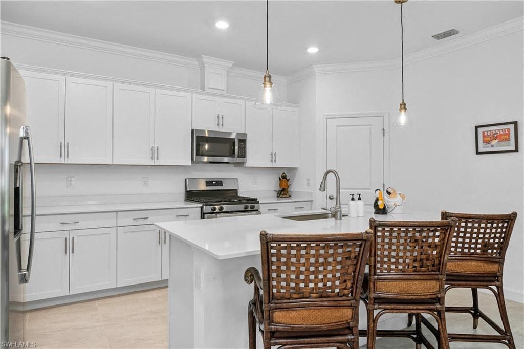 a kitchen with white cabinets and a table with chairs
