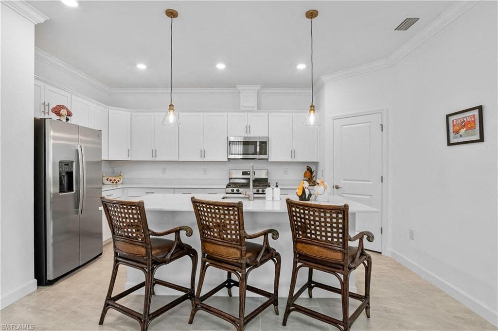 a kitchen with a counter and three chairs