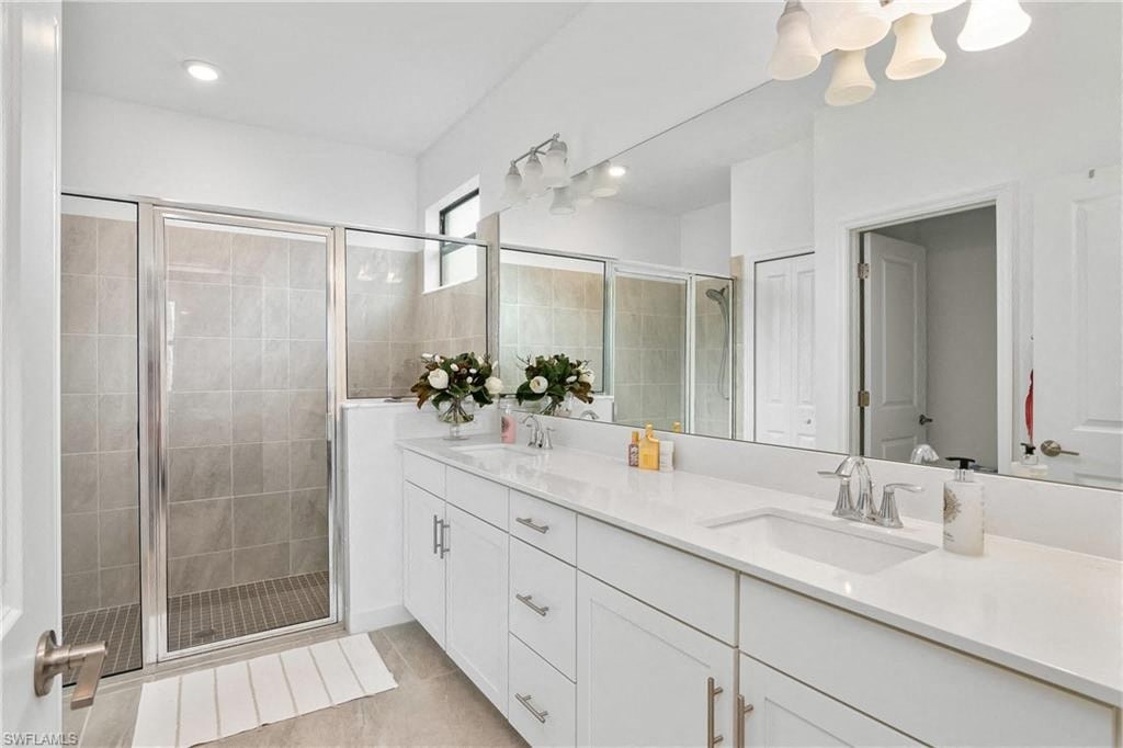 a white bathroom with a sink and a shower