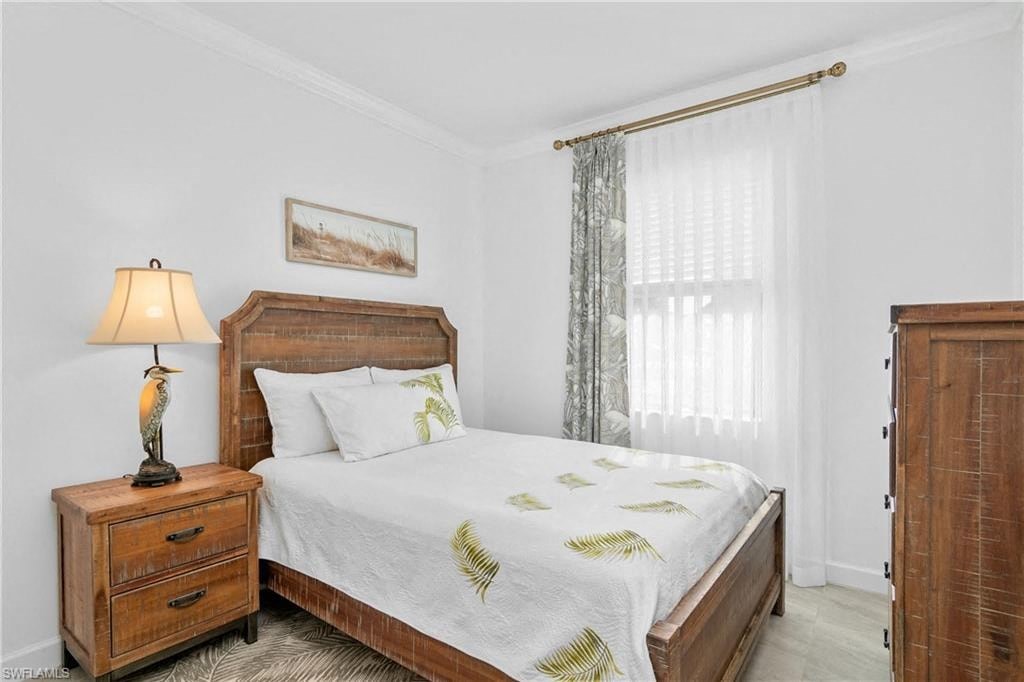 a bedroom with a bed and two dressers and a window