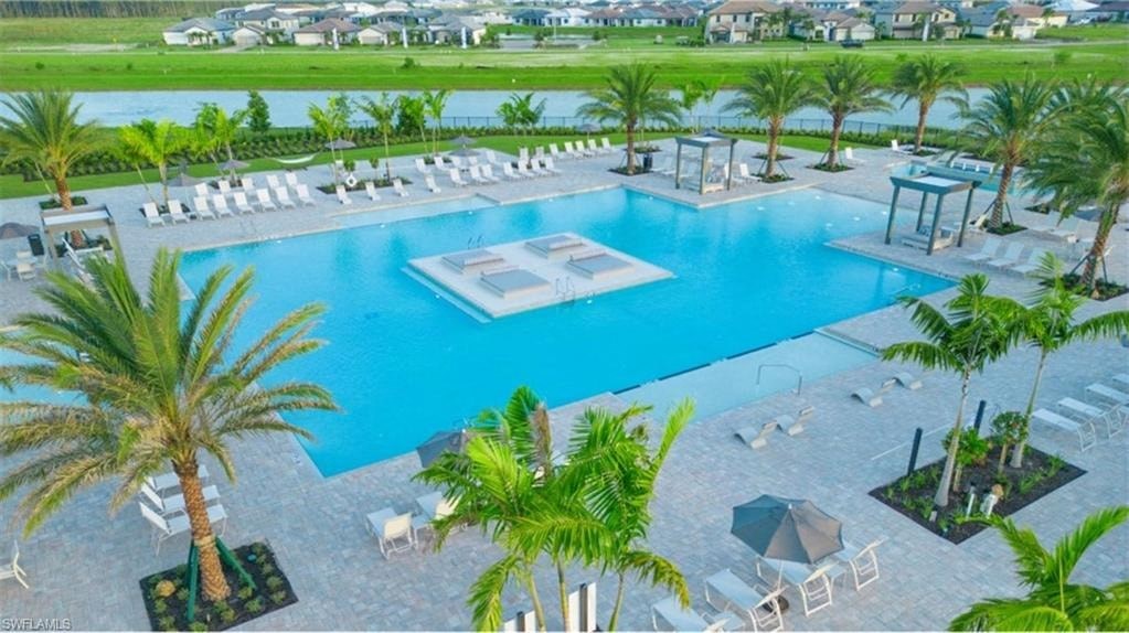 an aerial view of a large swimming pool with chairs and palm trees